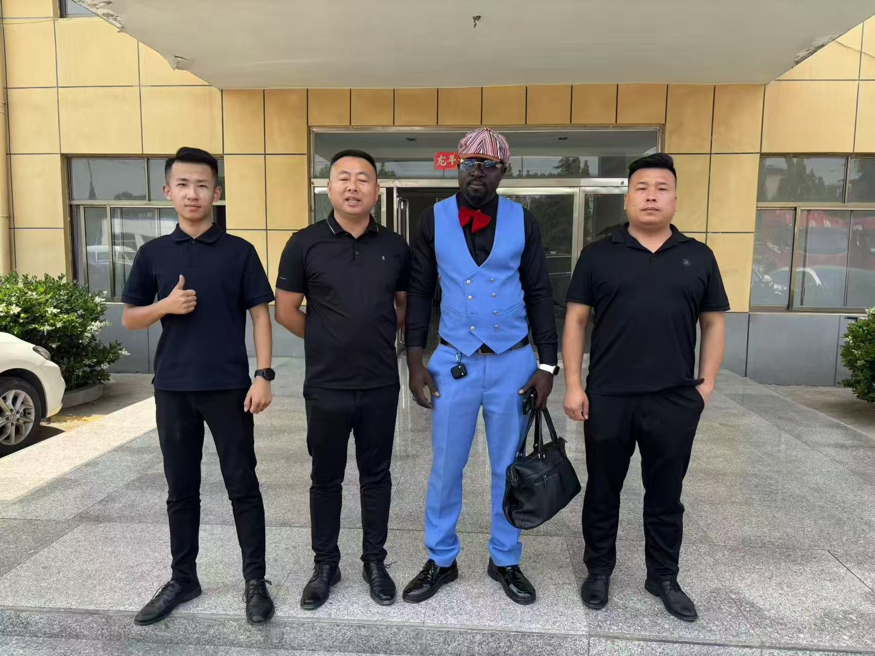 Visitors and Luhang staff standing together outside an office.